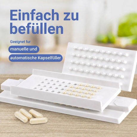 Kapselfüller mit befüllten weißen  Kapseln, die Kapseln sind geeignet für manuelle und automatische Befüllung